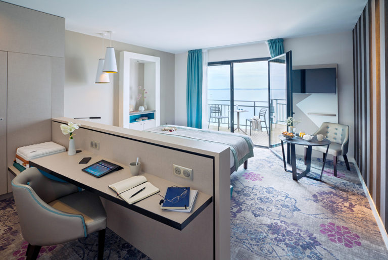 ambiance d'une chambre d'hôtel avec terrasse vue mer