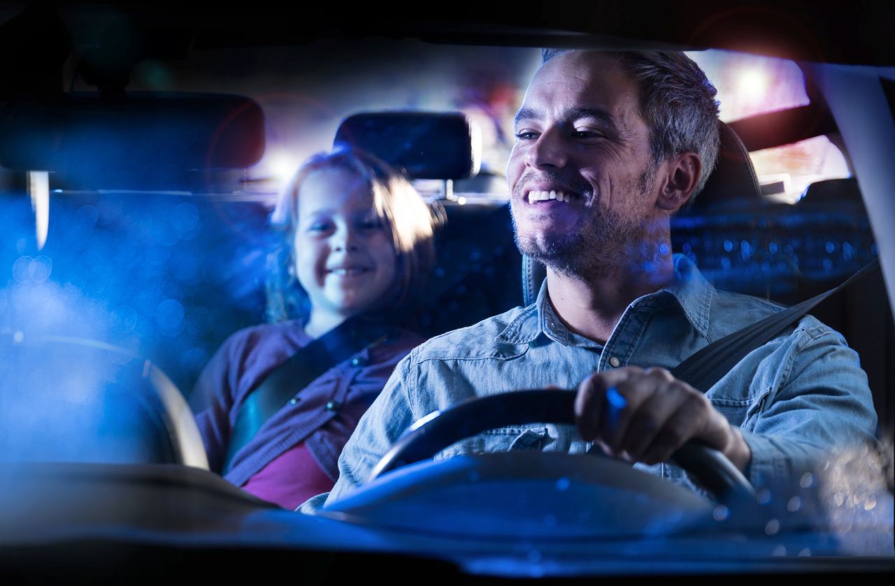 Photo lifestyle d'un père et sa fille dans une voiture la nuit