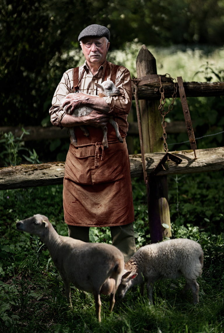 Photo d'un eleveur de mouton avec un agneau dans les bras
